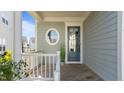 Inviting front porch with a round window, blue door, and wooden railing, creating a welcoming entrance at 1641 Silo Ridge Dr, Wake Forest, NC 27587