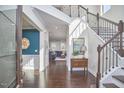 Bright foyer boasts hardwood floors, staircase with decorative railing, and an open view to the living room at 1808 Capstone Dr, Durham, NC 27713