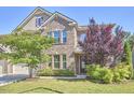 Landscaped front yard and brick facade with a welcoming entrance to this lovely home at 1808 Capstone Dr, Durham, NC 27713