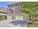Three car garage with ample parking space and lush landscaping around the property at 1808 Capstone Dr, Durham, NC 27713