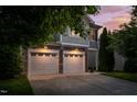Beautiful home exterior featuring a two-car garage with stone accents and a well-maintained lawn at 1908 Woodsdale Dr, Durham, NC 27703