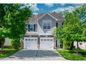Inviting home exterior with a two-car garage, gray siding, and a well-manicured front lawn at 1908 Woodsdale Dr, Durham, NC 27703