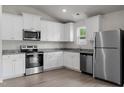 Modern kitchen with stainless steel appliances, granite countertops, and white cabinets providing lots of storage at 203 Benton Dr, Oxford, NC 27565