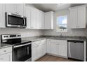 Bright kitchen with stainless steel appliances, light granite countertops, and sleek white cabinetry at 203 Benton Dr, Oxford, NC 27565