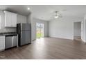 Open-concept living space featuring modern flooring, a ceiling fan, and sliding glass doors to the backyard at 203 Benton Dr, Oxford, NC 27565
