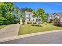 Beautiful two-story home with manicured front lawn and a long driveway on a sunny day at 208 Gillean Ln, Holly Springs, NC 27540
