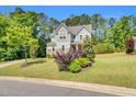 Two-story home with stone accents and well-maintained landscaping on a sunny day at 208 Gillean Ln, Holly Springs, NC 27540