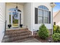 Inviting entryway with brick steps, black flowerpots, and an decorative door wreath at 2240 Delaney Dr, Burlington, NC 27215