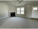Bright living room featuring a corner fireplace, neutral carpet, and a ceiling fan at 235 Starry Sky Dr, Benson, NC 27504