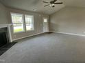 Spacious living room with a fireplace, neutral carpet, and lots of natural light at 235 Starry Sky Dr, Benson, NC 27504