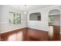 Bright dining area featuring hardwood floors, large windows, and a unique architectural cut-out at 2523 Ferdinand Dr, Knightdale, NC 27545