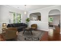 Bright living room featuring large windows, modern furniture, and an open archway into another room at 2523 Ferdinand Dr, Knightdale, NC 27545