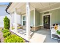 Inviting front porch with swing, stylish decor, and a 'Welcome' sign for a cozy entrance at 2531 Impulsion Dr, New Hill, NC 27562