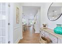 Bright hallway with hardwood floors, elegant decor, and a view into the open-concept living space at 2531 Impulsion Dr, New Hill, NC 27562