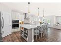 Modern kitchen features a large center island with seating, pendant lights, and stainless steel appliances at 2531 Impulsion Dr, New Hill, NC 27562