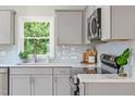 Kitchen boasts grey cabinets, stainless steel appliances, quartz countertops, and a subway tile backsplash at 2540 Atlantic St, Durham, NC 27707