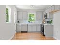 Bright kitchen boasts grey cabinets, stainless steel appliances, and hardwood floors at 2540 Atlantic St, Durham, NC 27707