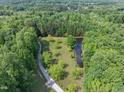 Beautiful property with a pond surrounded by lush green trees at 2600 Snow Hill Rd, Durham, NC 27712
