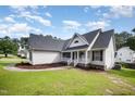 Inviting home exterior with white siding, gray roof, lush lawn, and inviting front porch at 2735 Clifton Ave, Creedmoor, NC 27522