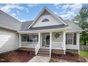 Charming front porch with white railings, brick accents, hanging plants, and a welcoming entrance at 2735 Clifton Ave, Creedmoor, NC 27522