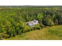 An aerial shot showcases the property, which includes a pool, detached garage, and a home surrounded by lush greenery at 3010 Blueberry Ln, Chapel Hill, NC 27516