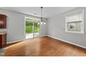 Bright dining area featuring hardwood floors, modern lighting, and sliding glass doors to the backyard at 3033 Remington Oaks Cir, Cary, NC 27519