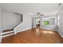 Spacious living room with hardwood floors, large windows, and a staircase leading to the upper level at 3033 Remington Oaks Cir, Cary, NC 27519
