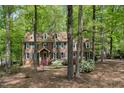 Traditional brick home with green shutters and dormer windows, nestled among mature trees and colorful azalea bushes at 309 Appaloosa Trl, Bahama, NC 27503