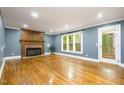 Spacious living room featuring hardwood floors, a classic fireplace, and large windows offering natural light and views at 309 Appaloosa Trl, Bahama, NC 27503