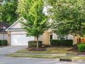 Charming single-Gathering home featuring a spacious two-car garage, manicured lawn, and mature trees at 33 Juliette Dr, Durham, NC 27713