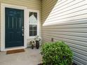 Cozy front entrance with a dark teal door, a welcoming doormat and decorative potted plants at 33 Juliette Dr, Durham, NC 27713