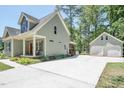 Side view of a quaint home showcasing a long driveway and a detached two-car garage at 3357 Denise St, Durham, NC 27704