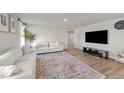 Modern living room with hardwood floors, a patterned rug, a comfortable sofa, and a large flat-screen TV at 36 High View Ct, Fuquay Varina, NC 27526