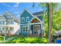 Charming two-story blue home features a welcoming front porch and well-maintained lawn at 407 1/2 Carolina Ave, Raleigh, NC 27606
