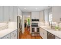 Modern kitchen with stainless steel appliances, white cabinets, and stylish backsplash at 4713 Little Falls Dr, Raleigh, NC 27609