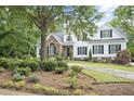 Charming two-story home featuring a blend of brick and white siding, complemented by a beautifully landscaped front yard at 4812 Cornoustie Ct, Holly Springs, NC 27540