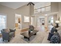 Open-concept living area with hardwood floors, natural light, a ceiling fan, and a view to the kitchen at 4812 Cornoustie Ct, Holly Springs, NC 27540