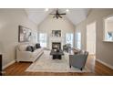Spacious living room with a fireplace, hardwood floors, a ceiling fan, and ample natural light at 4812 Cornoustie Ct, Holly Springs, NC 27540