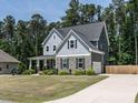 A beautiful home featuring a manicured lawn and long driveway leading to a two-car garage at 497 Rockport Dr, Clayton, NC 27527