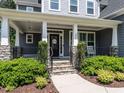 Inviting front porch with stone pillars and manicured landscaping, creating curb appeal at 497 Rockport Dr, Clayton, NC 27527