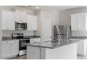 Kitchen featuring white cabinets, stainless steel appliances, and a stylish gray countertop at 507 Benton Dr, Oxford, NC 27565