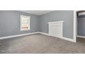 A bright bedroom with gray walls, white trim, gray carpet, and decorative mantel at 518 Avon Ave, Burlington, NC 27215