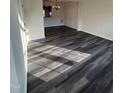 Open-concept living room with new dark-gray wood-look flooring and classic trim at 523 Berry Chase Way, Cary, NC 27519