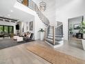 Open entryway with a winding staircase and modern chandelier, flowing into the spacious living area at 604 Dappled Pine Ave, Durham, NC 27713