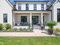 Inviting covered front porch with seating and manicured landscaping, complementing the home's striking facade at 604 Dappled Pine Ave, Durham, NC 27713