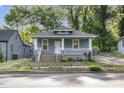 Inviting blue bungalow featuring a cozy front porch and well-maintained landscaping at 610 N Driver St, Durham, NC 27703