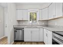 Updated kitchen with white cabinets, stainless steel appliances, and granite countertops at 7407 Sandy Creek Dr, Raleigh, NC 27615