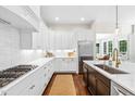 Bright kitchen featuring white cabinetry, stainless steel appliances, and a spacious center island with a sink at 7544 Hasentree Club Dr, Wake Forest, NC 27587