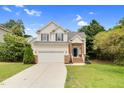 Charming two-story home with a well-maintained lawn, attached garage, and classic architectural details at 8820 Waynick Dr, Raleigh, NC 27617