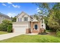 Charming two-story home with a well-maintained lawn, attached garage, and classic architectural details at 8820 Waynick Dr, Raleigh, NC 27617